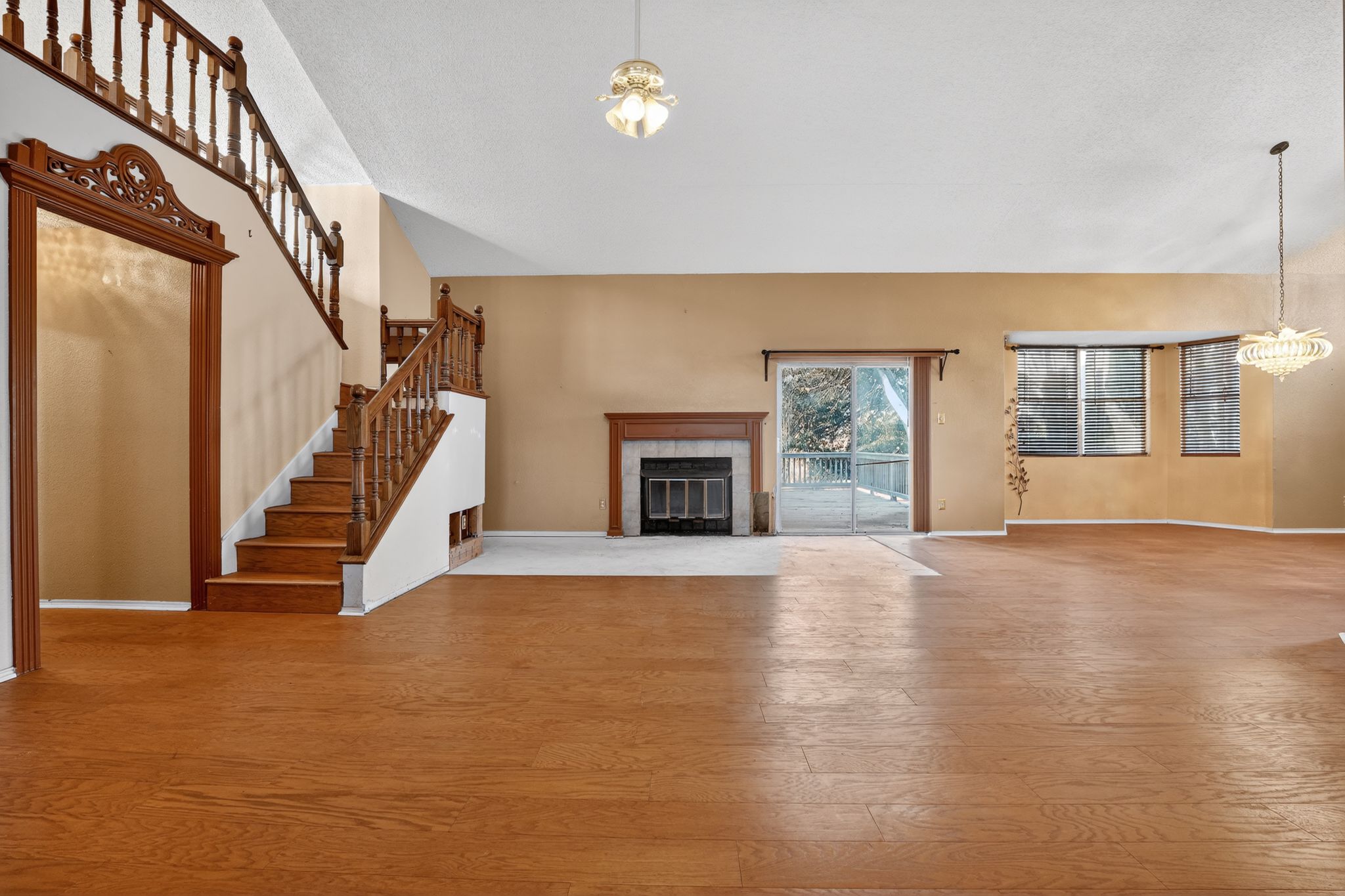 2113 Cervin Boulevard Austin, TX 78728 - Photo 10 of 27 Unfurnished living room featuring suspended lighting, wood finished floors, a tile fireplace, and lofted ceiling