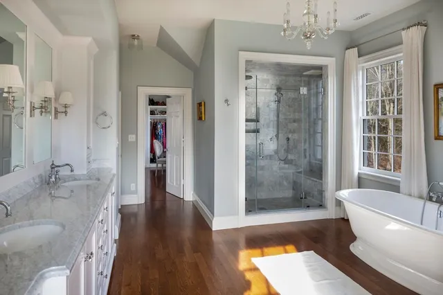 a bathroom with a tub shower and window