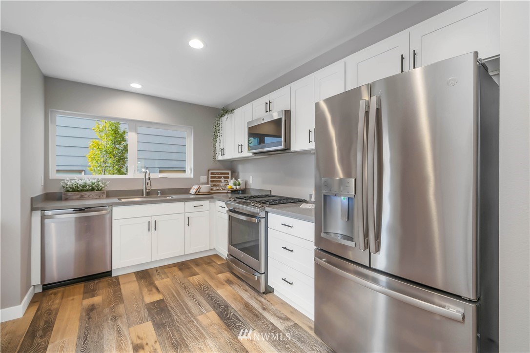 423 Martin Luther King Jr Way South, Unit A Seattle, WA 98144 - Photo 14 of 31 a kitchen with stainless steel appliances granite countertop a refrigerator sink and stove