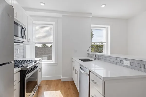 a kitchen with stainless steel appliances granite countertop a sink stove and cabinets