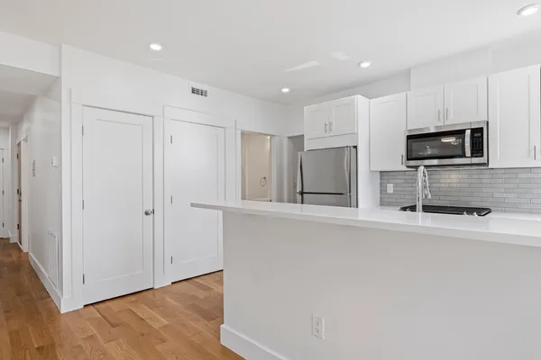 a kitchen with stainless steel appliances a refrigerator and a stove top oven