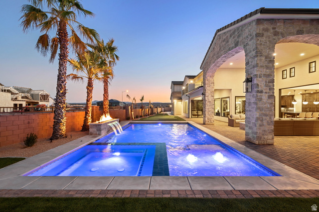 4871 South Homestead Way Washington, UT 84780 - Photo 124 of 151 Pool at dusk featuring a patio area, a fenced backyard, and a pool with connected hot tub