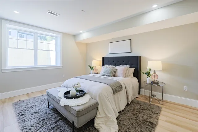 a bedroom with a bed and wooden floor