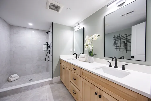 a bathroom with a double vanity sink mirror double and shower