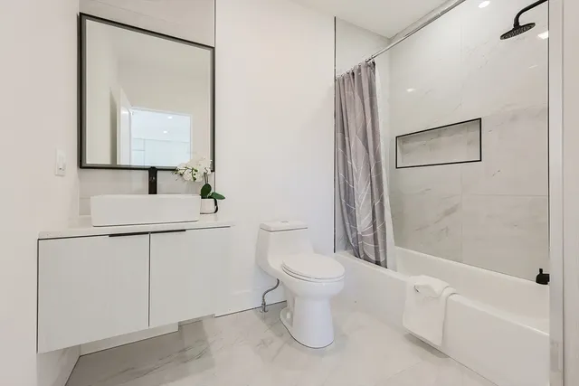 a bathroom with a toilet sink and mirror