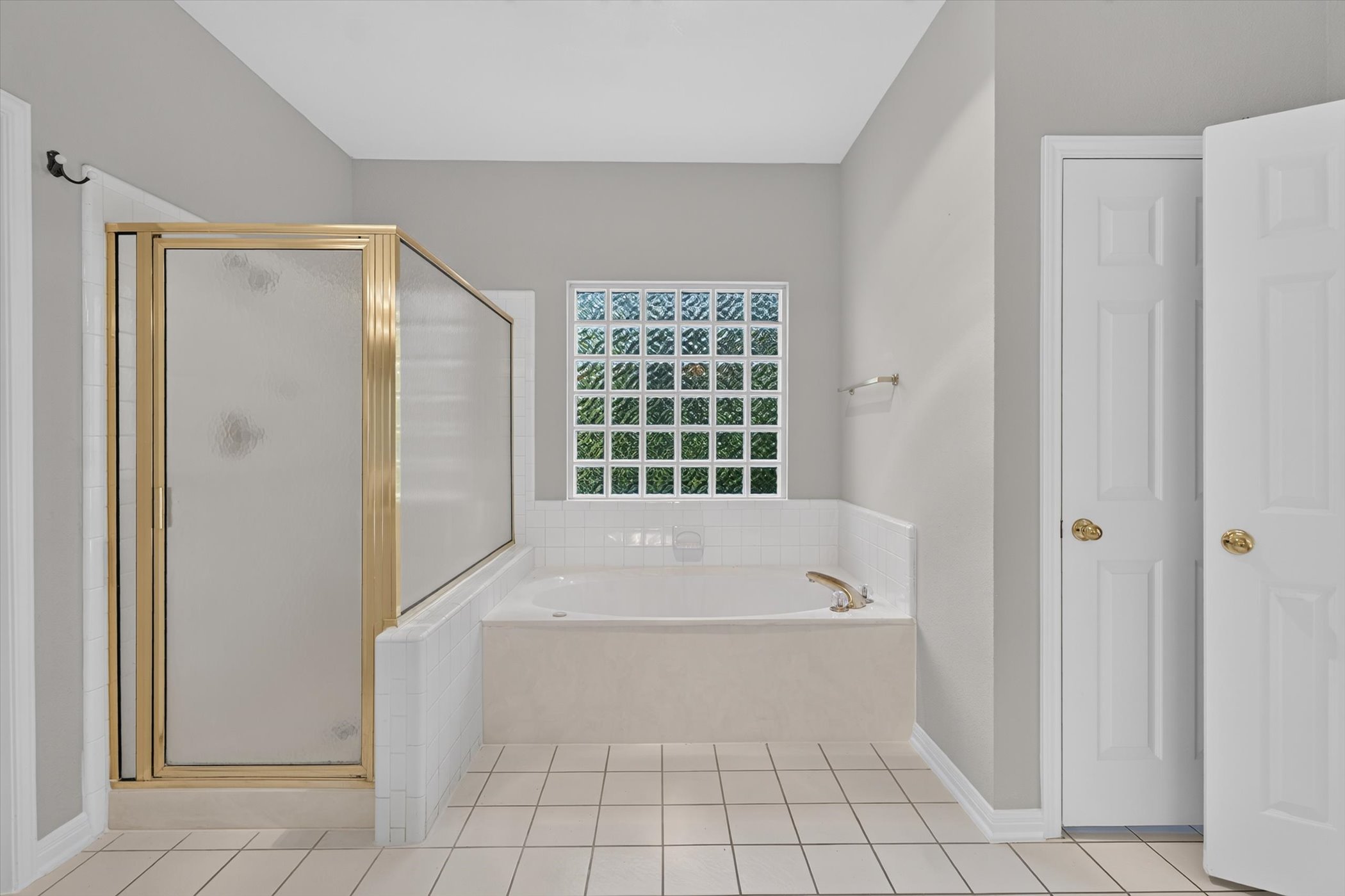 13615 Copperleaf Trail Manchaca, TX 78652 - Photo 22 of 38 Indulge in a relaxing soak within this primary bathroom featuring a tub and a glass-enclosed shower.