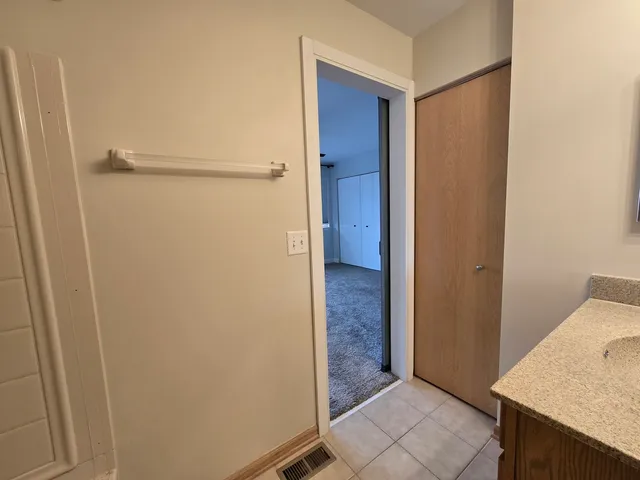 a view of a hallway with closet and wooden floor