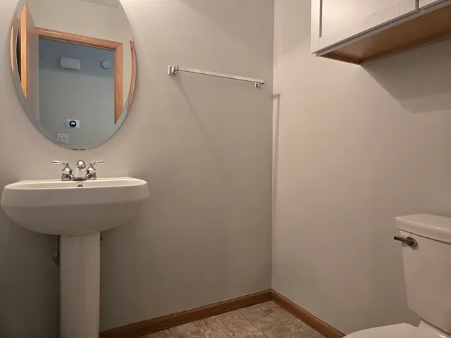 a bathroom with a sink toilet and mirror