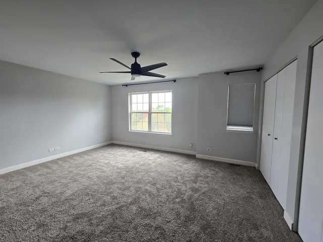 an empty room with windows and closet