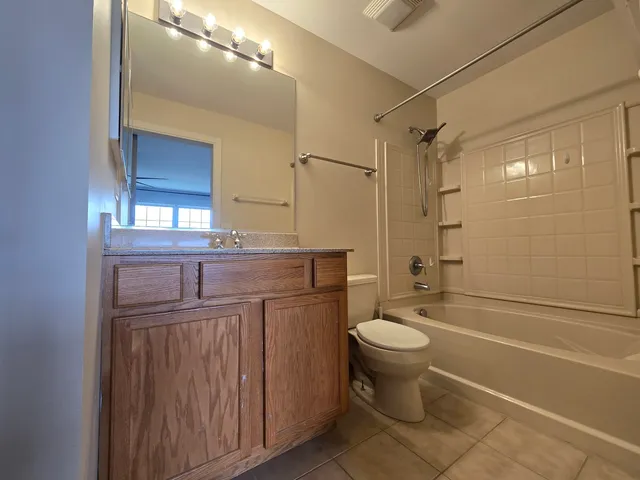 a bathroom with a granite countertop toilet a sink and a mirror