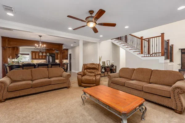 a living room with furniture a ceiling fan and a rug