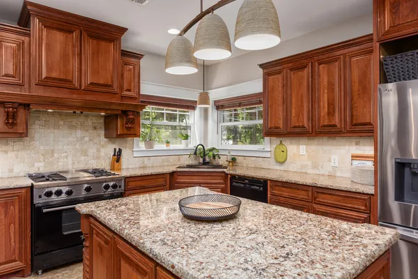 a kitchen with stainless steel appliances granite countertop a stove a sink and a microwave