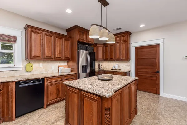 a kitchen with stainless steel appliances granite countertop a sink a stove and a refrigerator