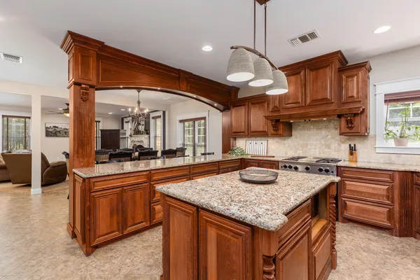 a kitchen with granite countertop stainless steel appliances a stove sink and cabinets