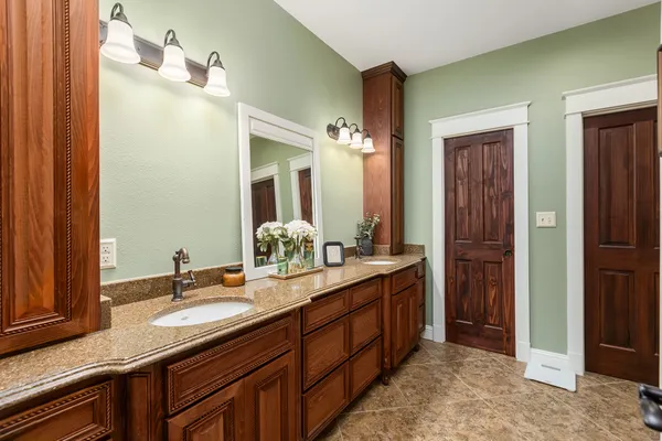 a bathroom with a double vanity sink and mirror with shower