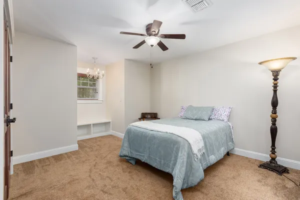 an empty room with closet and fan