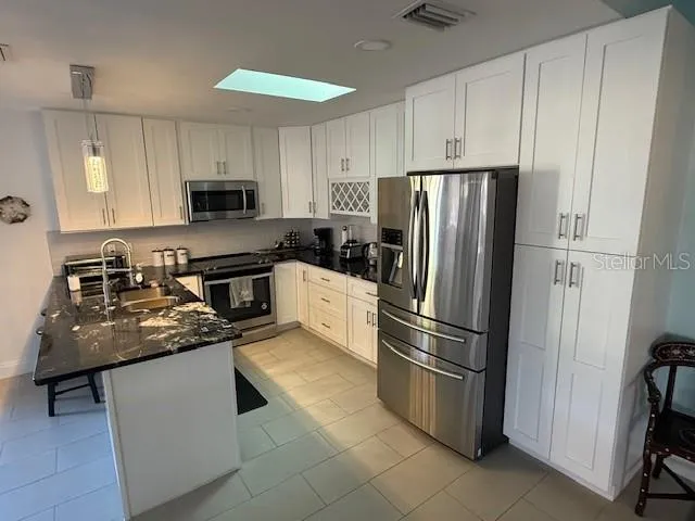 a kitchen with stainless steel appliances granite countertop a refrigerator sink and stove