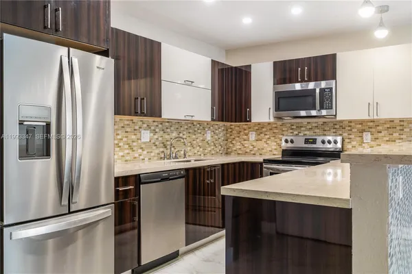 a kitchen with stainless steel appliances granite countertop a refrigerator and a stove