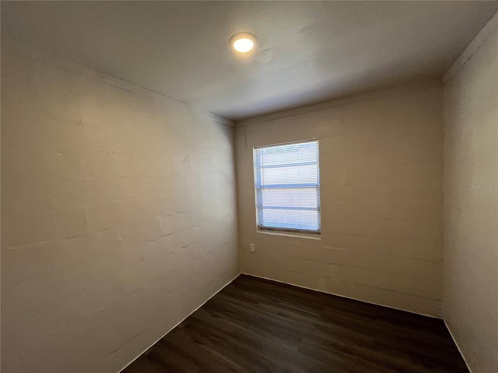 1339 Winnifred Street Orlando, FL 32805 - Photo 12 of 13 an empty room with wooden floor and windows
