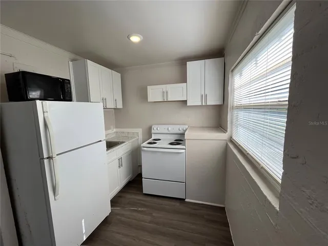 a utility room with wooden floor washer and dryer