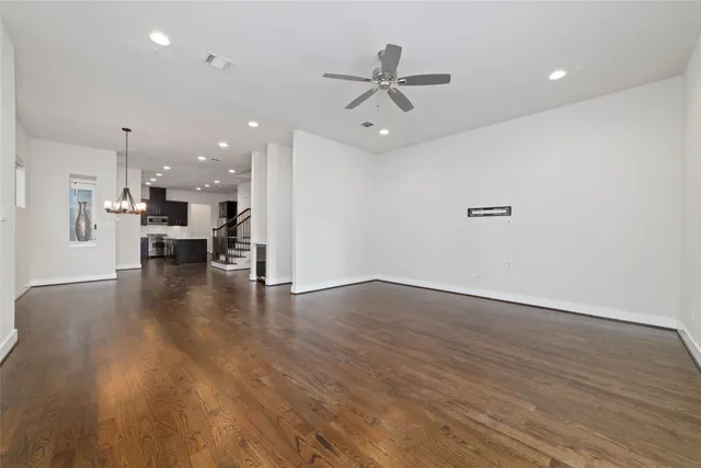 a view of a kitchen with a wooden floor and a ceiling fan