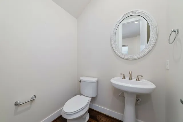 a bathroom with a toilet a sink and a mirror