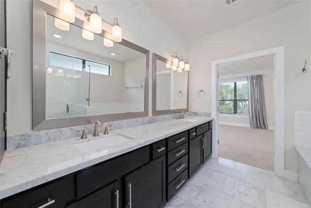 a bathroom with a granite countertop sink double vanity and a mirror