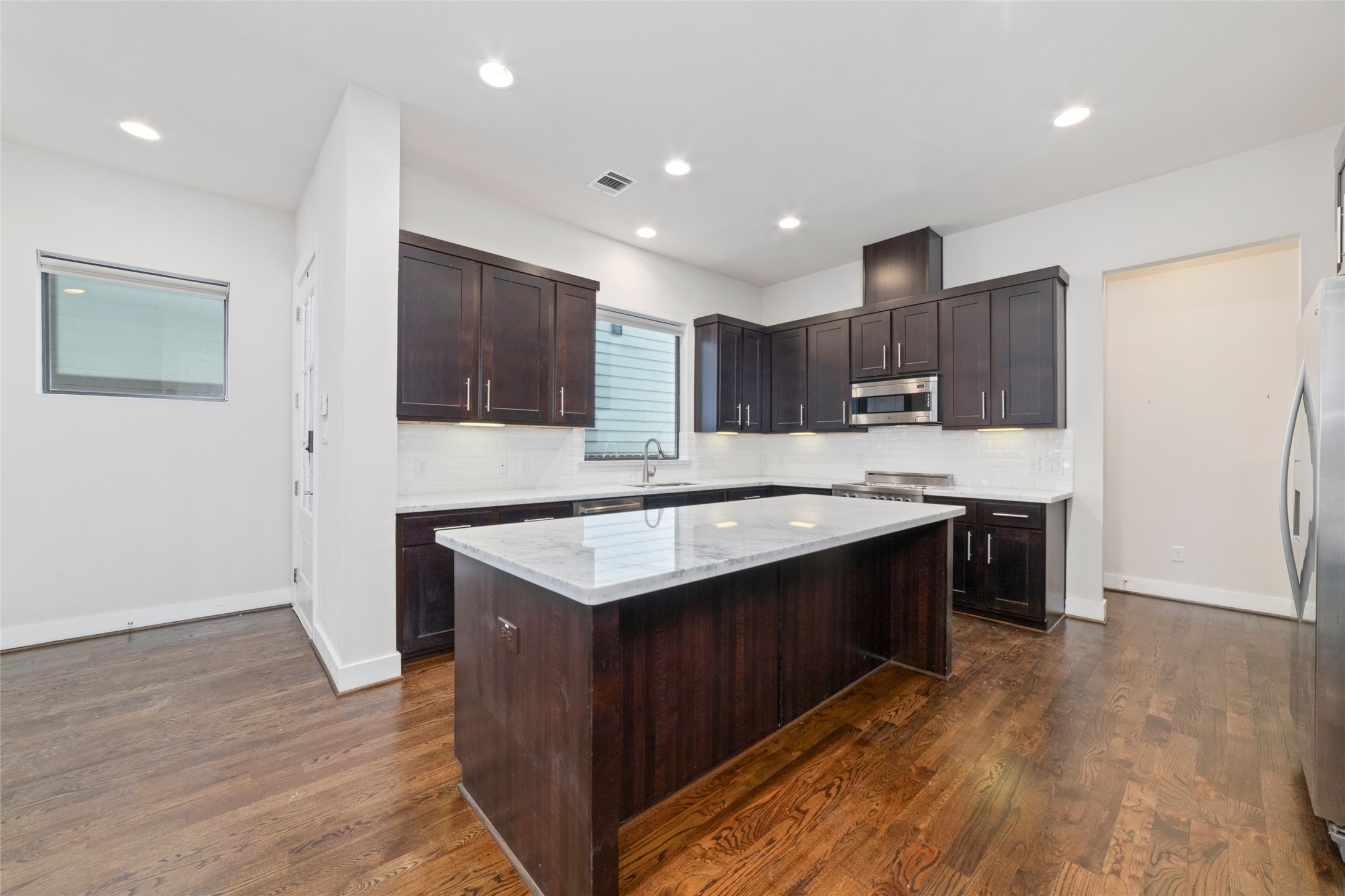 1917 West 15th Street, Unit A Houston, TX 77008 - Photo 5 of 34 a kitchen with kitchen island granite countertop a sink and a stove top oven