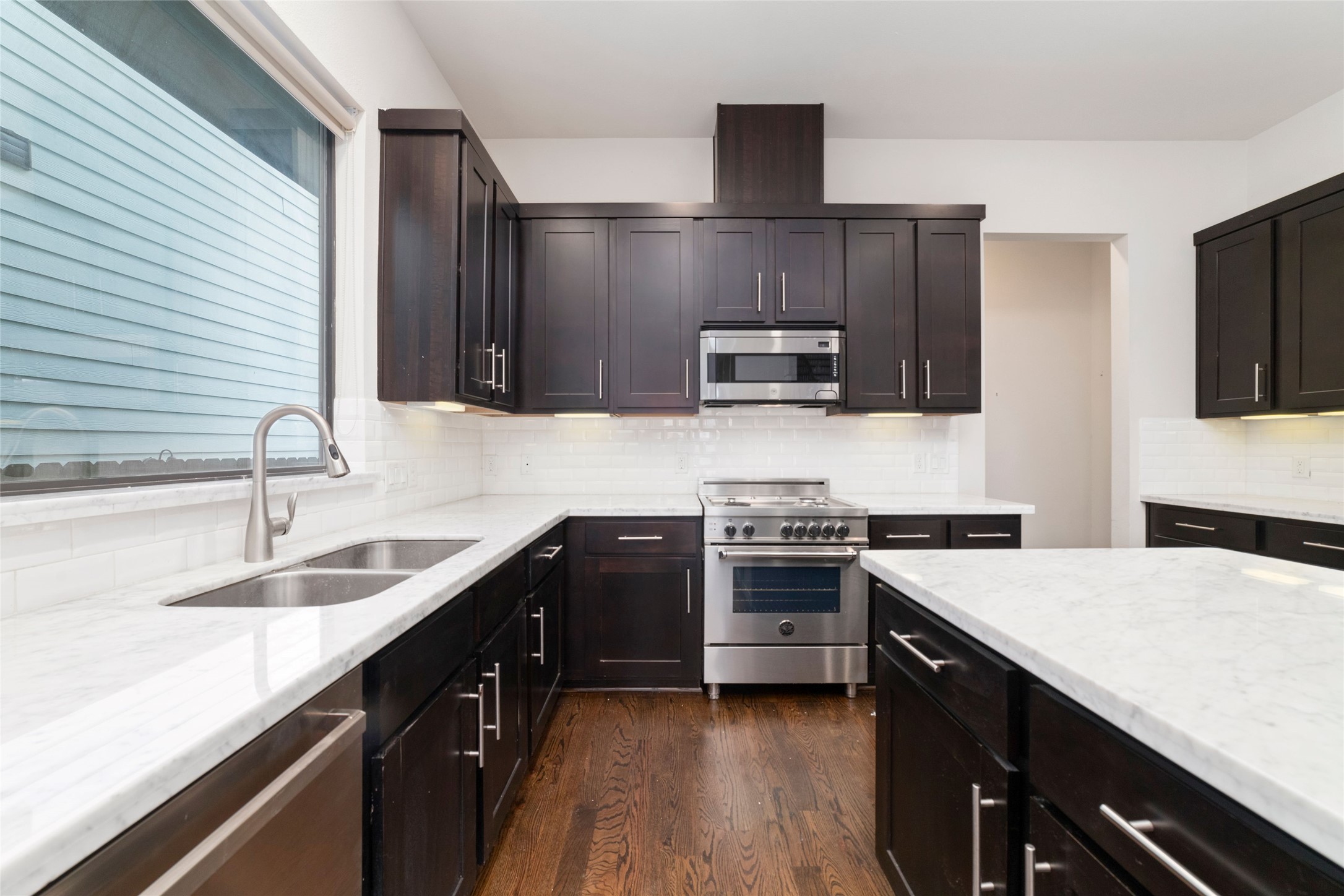 1917 West 15th Street, Unit A Houston, TX 77008 - Photo 6 of 34 a kitchen with kitchen island granite countertop a sink stainless steel appliances and cabinets