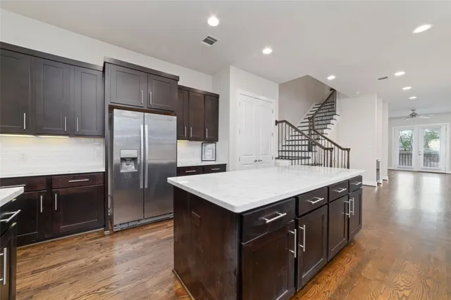 a kitchen with stainless steel appliances granite countertop a sink a refrigerator and a stove