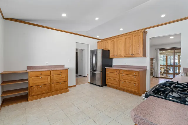 a kitchen with stainless steel appliances kitchen island granite countertop a refrigerator and cabinets