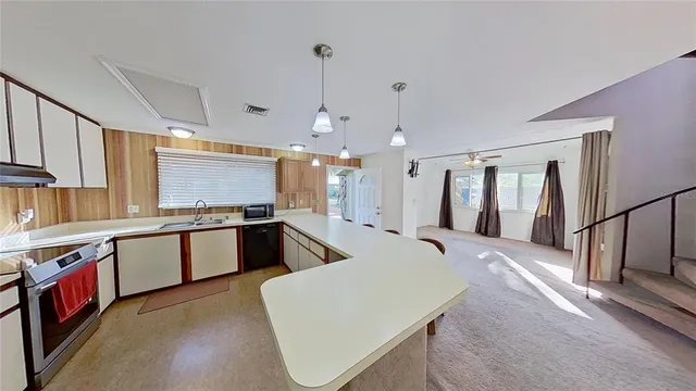 a large white kitchen with lots of counter space a sink and appliances