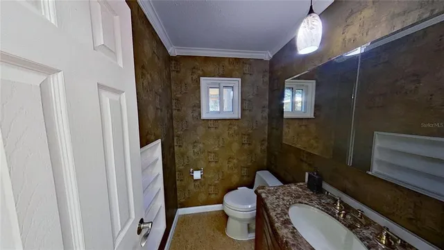 a bathroom with a granite countertop toilet sink and mirror