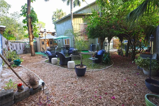 a view of a house with backyard and trees
