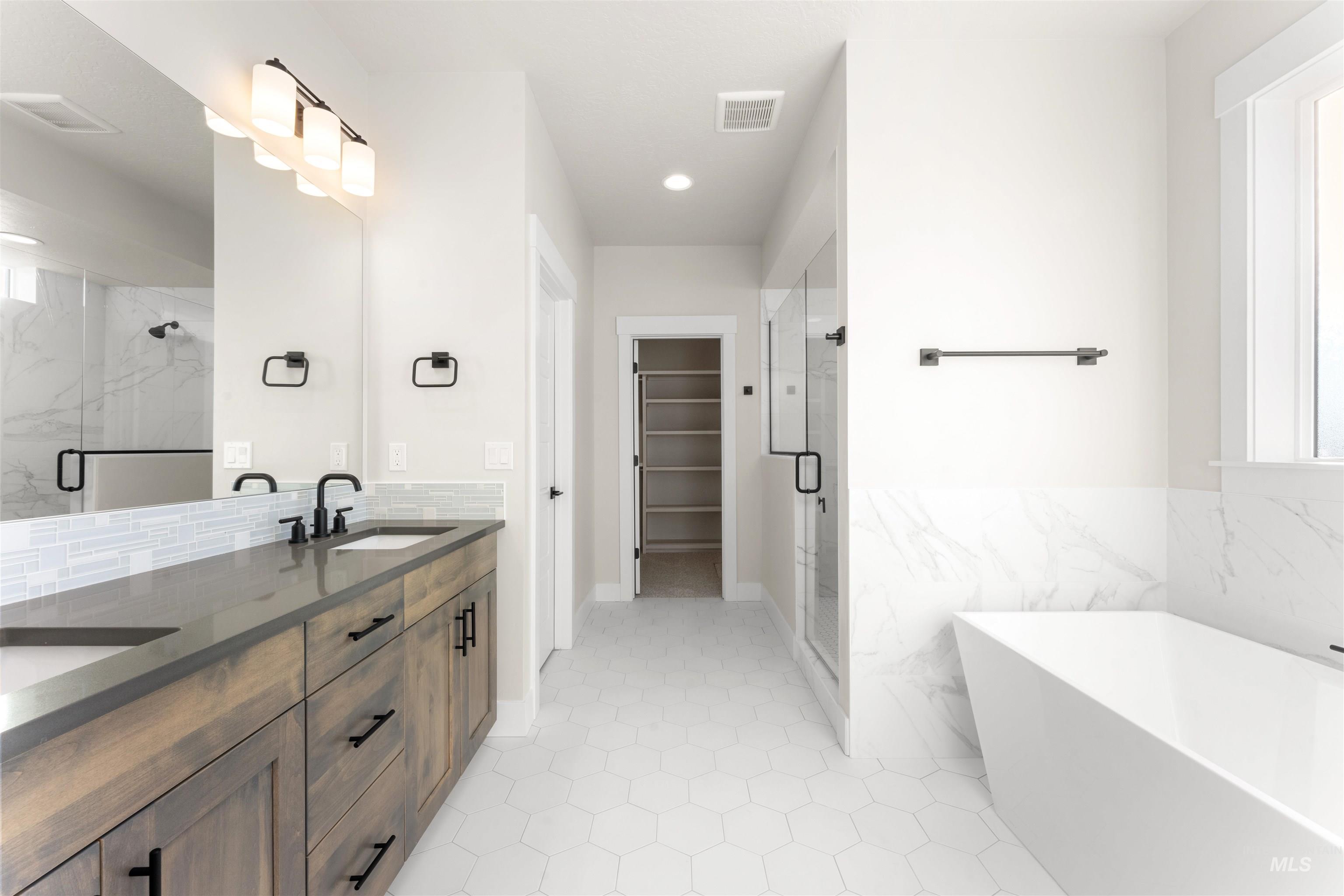 8076 Tandy Cv Street Middleton, ID 83644 - Photo 21 of 41 Full bathroom with double vanity, a spacious closet, a soaking tub, and a marble finish shower