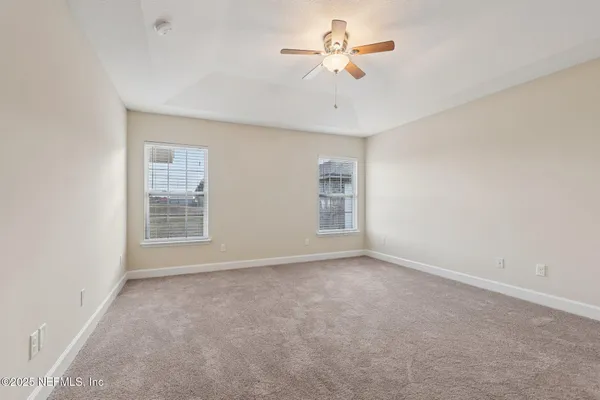 a view of an empty room with a ceiling fan