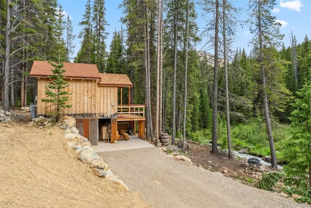 a view of a house with backyard and trees