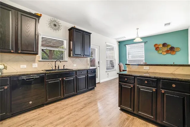 a kitchen with a refrigerator and wooden floor