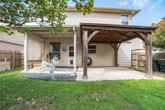 a view of a backyard with lawn chairs and plants
