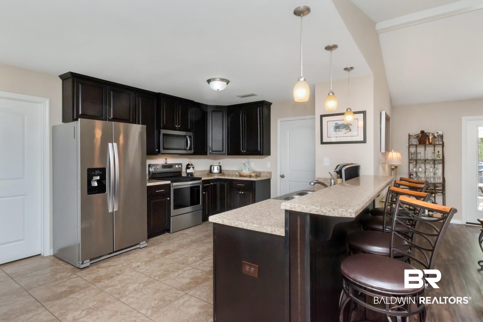11528 Mocking Bird Lane Fairhope, AL 36532 - Photo 15 of 45 Kitchen with stainless steel appliances, light countertops, a kitchen bar, pendant lighting, and a peninsula
