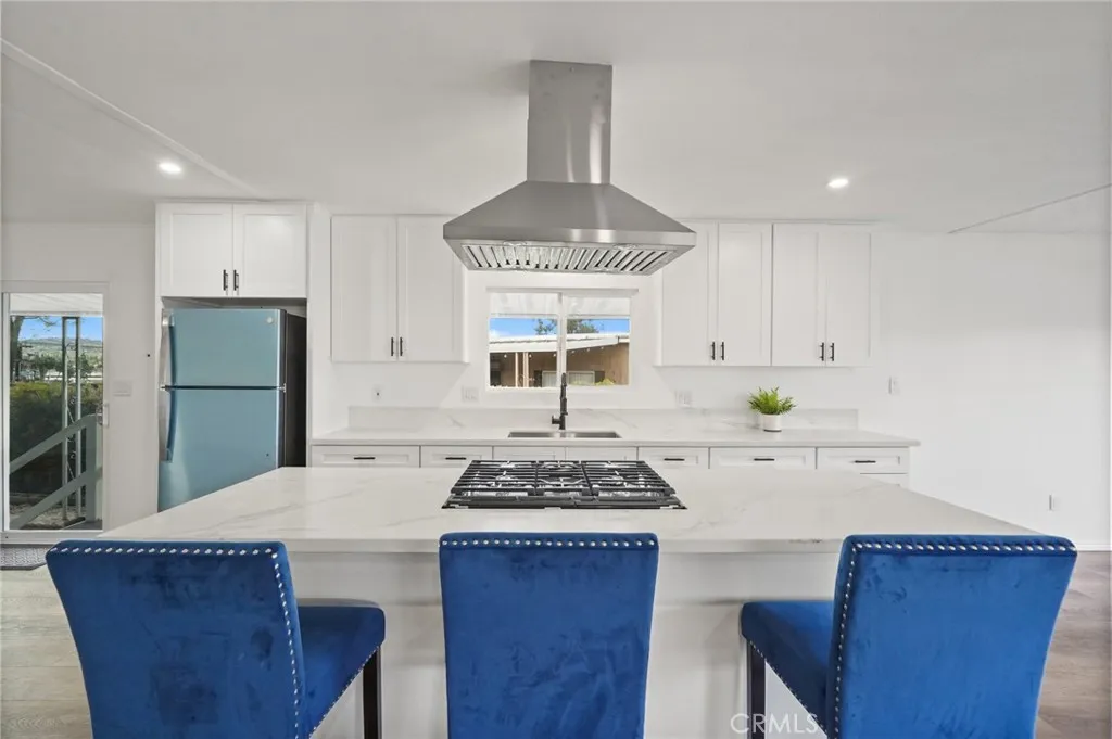 3033 E Valley, Unit 89 West Covina, CA 91792 - Photo 17 of 55 a kitchen with a stove a sink a refrigerator dining table and chairs