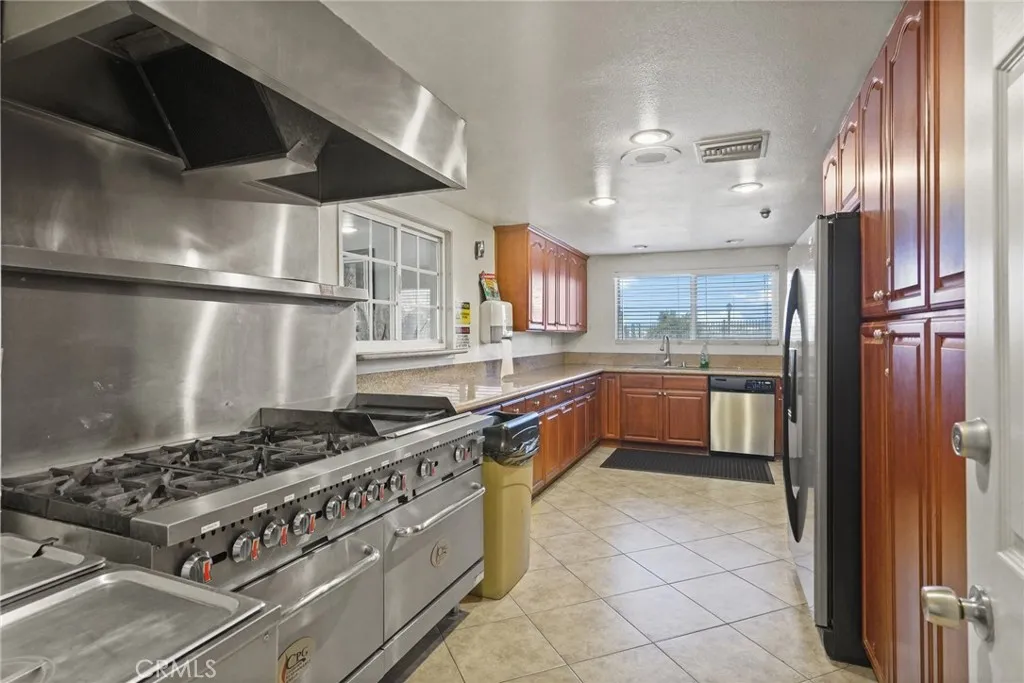 3033 E Valley, Unit 89 West Covina, CA 91792 - Photo 43 of 55 a kitchen with a stove a sink and a refrigerator