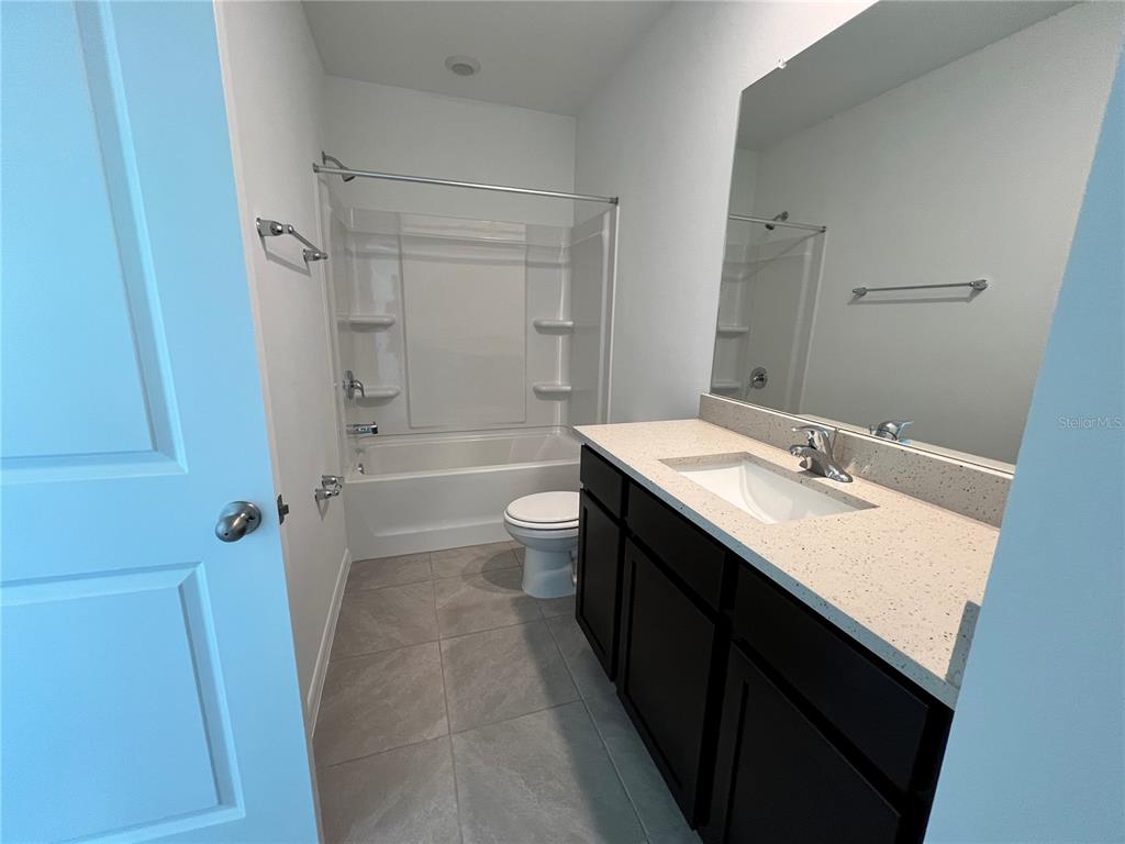 137 Mangrove Shade Circle Apollo Beach, FL 33572 - Photo 20 of 31 a bathroom with a granite countertop sink toilet a shower and a tub
