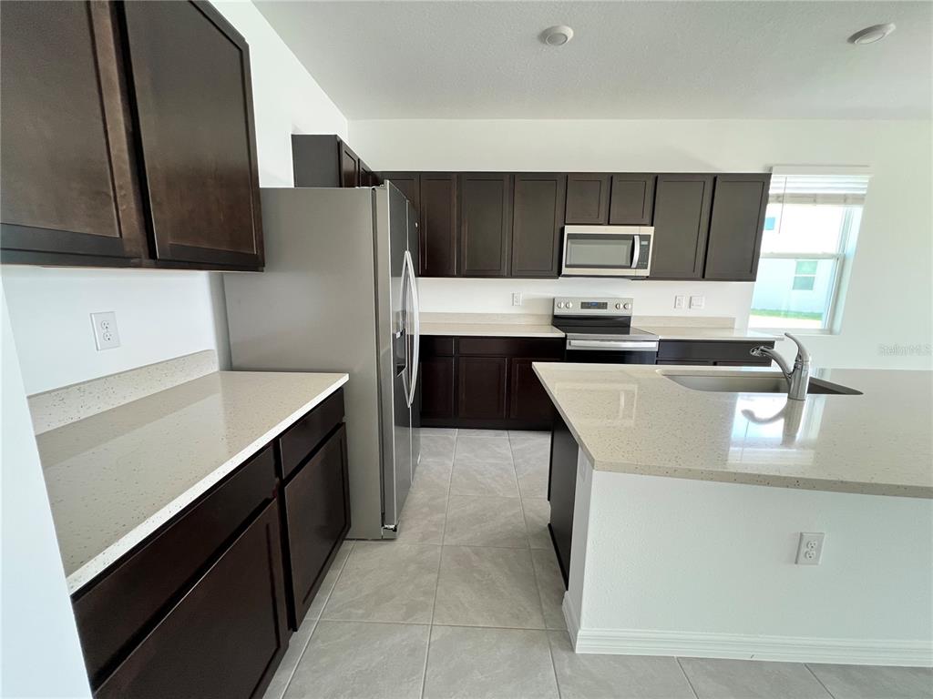 137 Mangrove Shade Circle Apollo Beach, FL 33572 - Photo 4 of 31 a kitchen with stainless steel appliances a sink and a refrigerator