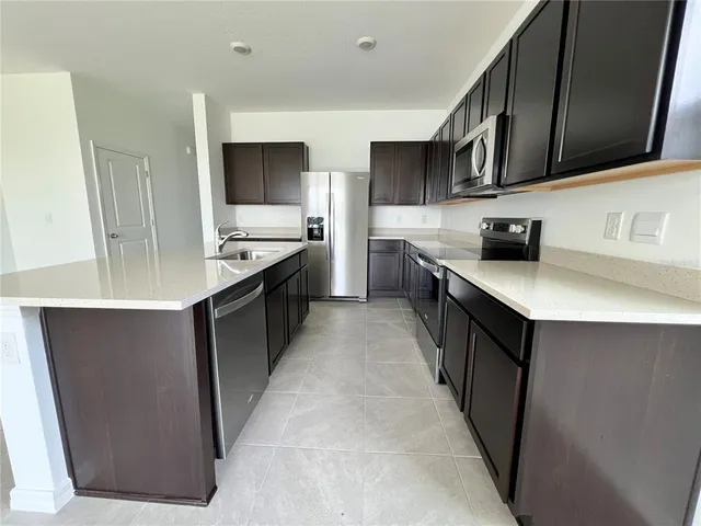 a kitchen with stainless steel appliances a sink stove top oven and wooden cabinets