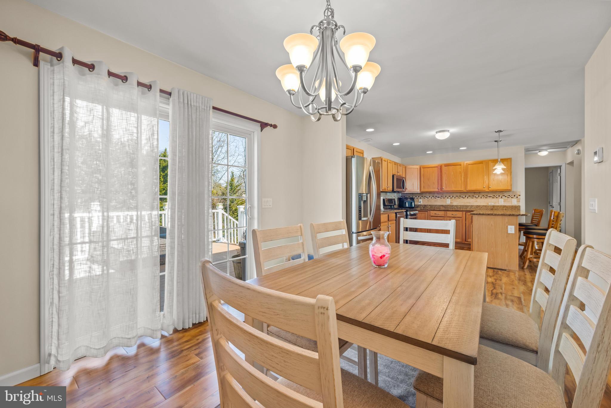 141 Pine Trail Delta, PA 17314 - Photo 14 of 44 a dining room with wooden floor a chandelier a wooden table and chairs