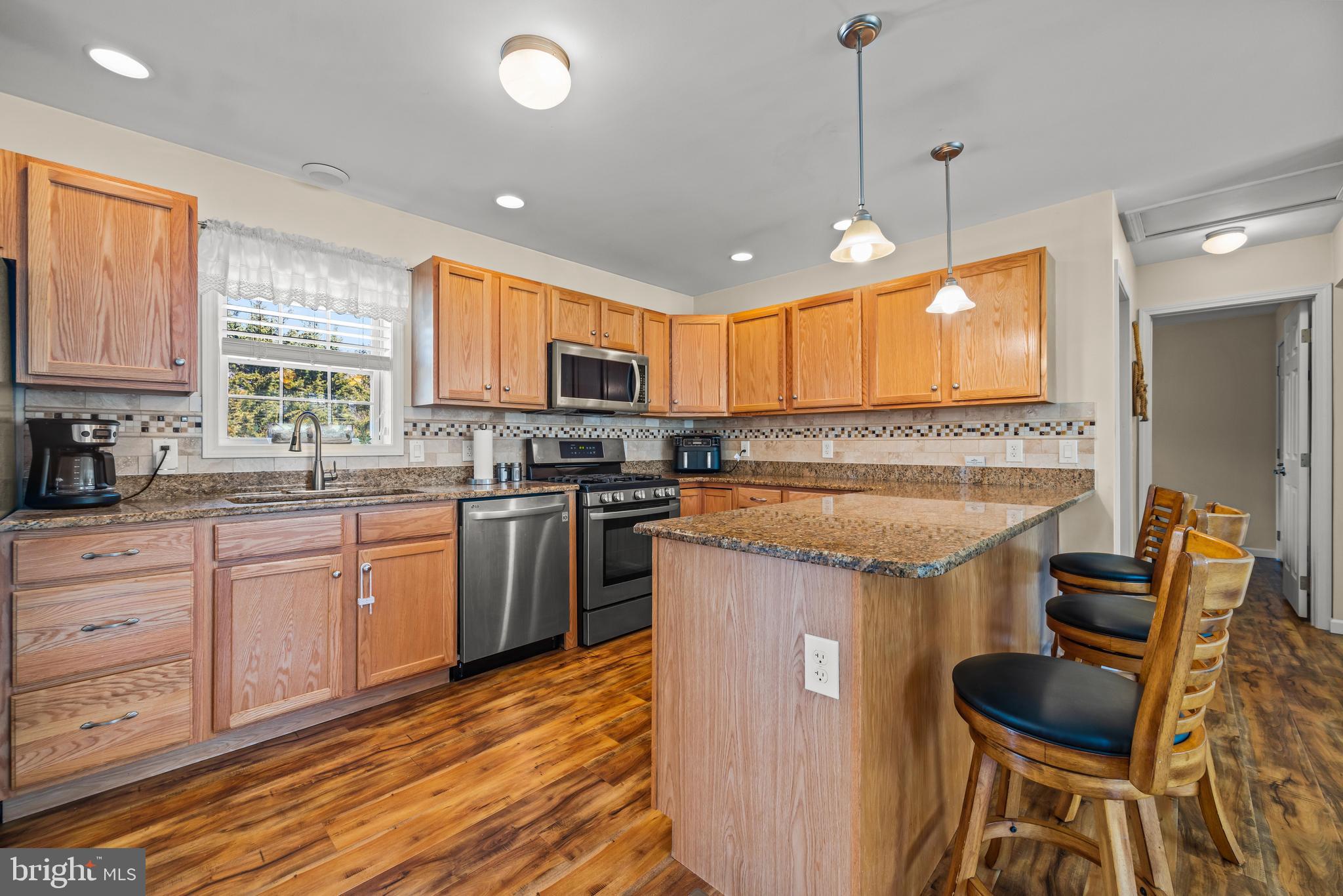 141 Pine Trail Delta, PA 17314 - Photo 9 of 44 a kitchen with stainless steel appliances granite countertop a stove a sink and a refrigerator with wooden floor