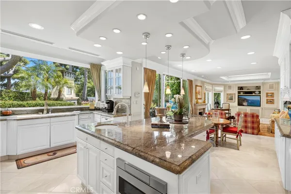 a kitchen with stainless steel appliances granite countertop sink stove dining table and chairs