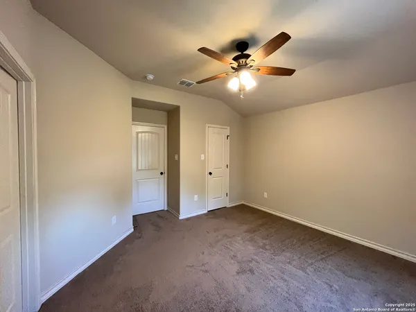 an empty room with window and ceiling fan