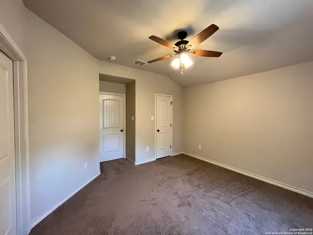 an empty room with window and ceiling fan